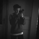 Schwarz-weiß Spiegel-Selfie eines jungen Mannes mit Mütze und Pullover – stilvolles, minimalistisches Porträt mit dunkler Atmosphäre
