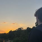 Silhouette einer Person, die in den Sonnenuntergang blickt – stimmungsvolle Szene mit warmen Farben und ruhiger Atmosphäre
